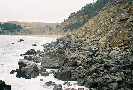 [Either there was a rock-slide or the ocean washed up hundreds of small boulders which the ocean is lapping.]